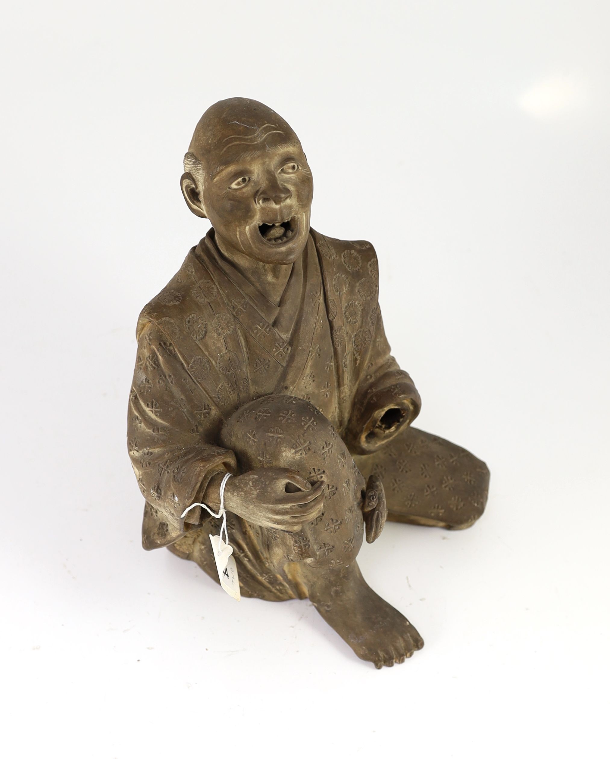 A Japanese terracotta figure of a kneeling and shouting man, 26cm high